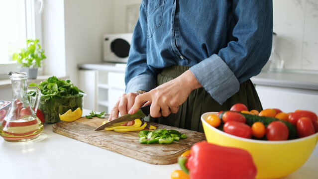 Woman Slicing Yellow Pepper - Powered by Adobe