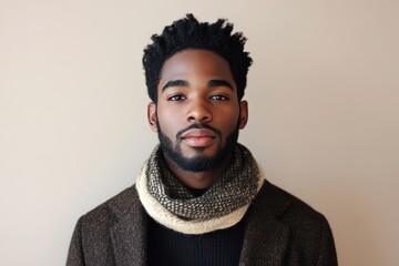 Obraz premium Young adult male with dark skin and natural hair poses looking directly forward