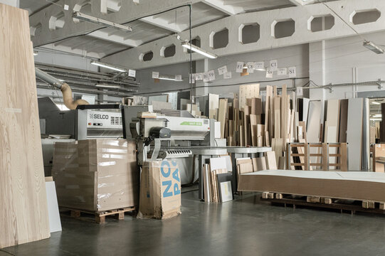 Stacked wooden planks fill a warehouse setting, neatly organized on pallets. Concept of sustainable forestry, resource management, or raw materials. Smolevichi, Belarus - September 25, 2025