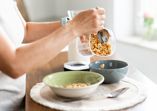 Woman Pouring Cereal Into Bowl