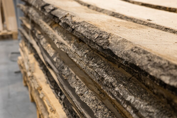 Stacked logs with textured bark fill the frame, showcasing natural wood grain. Concept of sustainable forestry, raw materials, or rustic construction is conveyed.