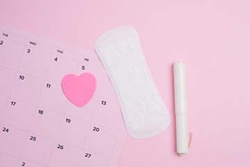 Menstrual cycle tracking calendar with sanitary products and  pink heart 