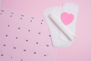 Menstrual cycle tracking calendar with sanitary products and  pink heart 