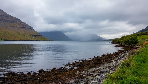 Pemandangan pantai yang dramatis dengan pegunungan dan langit yang suram