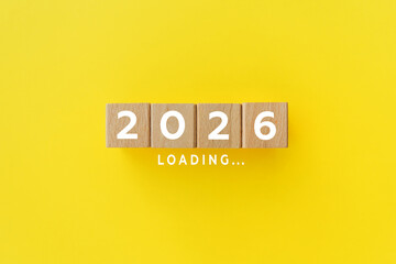 2026 New Year Loading. Loading bar with wooden blocks on yellow background. Start new year 2026 with goal plan, goal concept, action plan, strategy, new year business vision.