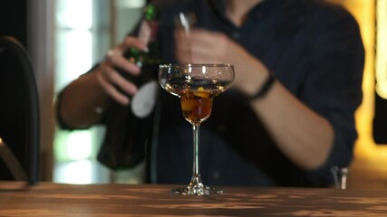 A bartender pouring a drink into a martini glass