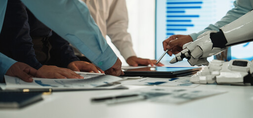 A dynamic workspace where human hands collaborate with a robotic arm, analyzing data and creating plans, surrounded by charts and graphs showcasing results.Noogenesis