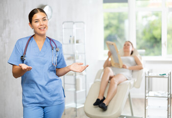 Obraz premium Young woman doctor cosmetologist posing in medical office