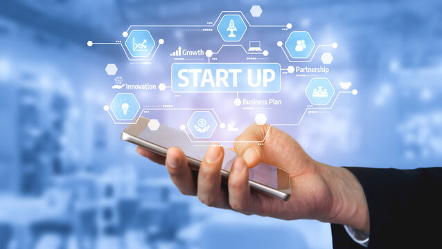 Hand Holding Smartphone with Digital Startup Concept on Screen Featuring Growth, Innovation, Partnership, and Business Plan on Blurred Background. Tessel.