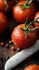 Close-up of fresh, red tomatoes with water droplets, a knife, and peppercorns on a wooden surface. The image has a dark, moody aesthetic.