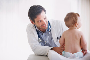Healthcare, pediatrics and smile of doctor with baby in hospital for checkup or development. Appointment, examination or medical with happy pediatrician man and infant child in clinic for assessment