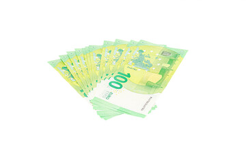 Fan of 100 euro banknotes arranged on a plain white background, showing the green tones and security details of the bills.