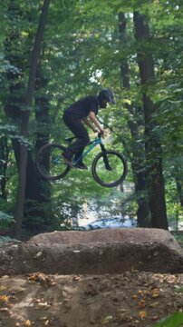Athlete shows tailwhip and 360 tricks on bike jumping over hills