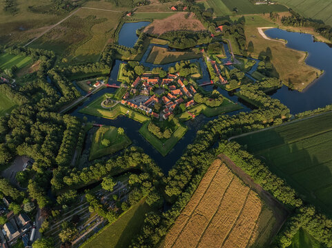 Aerial view of the star-shaped fortress of Bourtange, a symphony of red roofs and green moats, nestled amidst the Dutch countryside, Bourtange, Groningen, Netherlands.