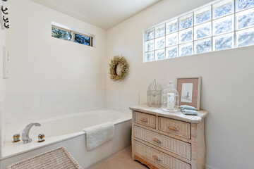 A stylish bathroom that features a cozy bathtub and a wooden dresser