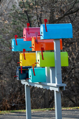 A group of colorful birdhouses made from mail boxes.