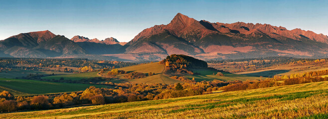 Golden autumn fields below the imposing mountains.
