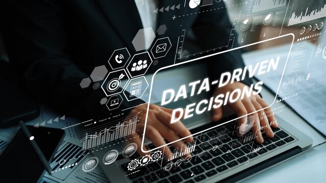 Professional working on laptop illustrating data-driven decisions with digital analytics and technology graphics overlay. Asymptotic smart data analytic.