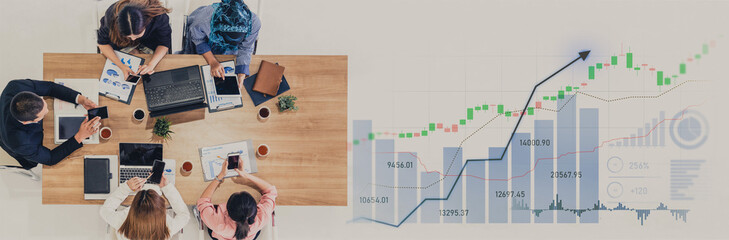 A diverse group of professionals meets to analyze charts and data in a modern workspace, showcasing teamwork and strategic planning for business growth. Scalp