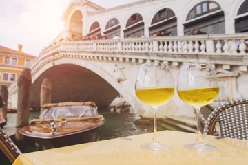 Fotobehang Rialtobrug Celebrating Venice with wine glasses and Rialto Bridge  © anatoliycherkas