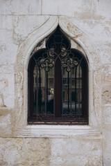 Gothic arched window with elaborate wrought iron grille