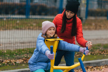 A young woman, mother, trainer, and a beautiful, strong teenage daughter, a happy family, are...