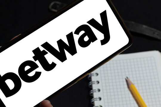 Cell phone with Betway on screen taken on a notebook and pencil, environment linked to sports betting and odds analysis