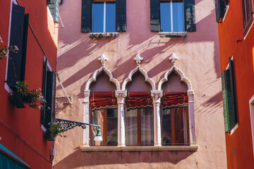 Traditional Venetian building facade with Gothic windows and shutters