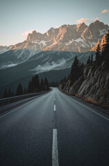Fototapeta premium Winding Road Through Majestic Mountains at Sunset