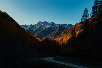 Panorama di montagna in Italia con i colori autunnali del foliage e cime innevate