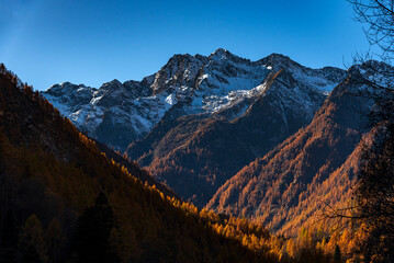 Fototapeta premium Panorama di montagna in Italia con i colori autunnali del foliage e cime innevate