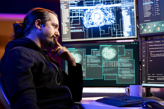 Pensive cybercriminal coding on PC, brainstorming ways to evade security with stealth malware. Evil man thinking how to use exploit hiding malicious code from detection systems - Powered by Adobe