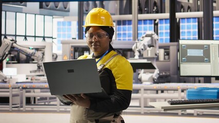 Engineer performing predictive maintenance using laptop, analyzing IoT sensor data, managing operational reliability of photovoltaic systems in smart factory environment, camera A