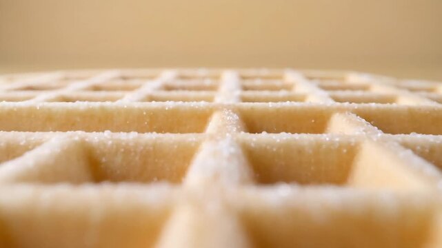 Macro close up low angle of a classic beige square waffle covered with sparkling sugar crystals
