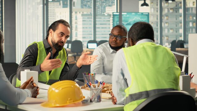 Diverse group of colleagues consulting on a master plan for urban development. Property developers review architectural software and construction designs to achieve real estate growth. - Powered by Adobe