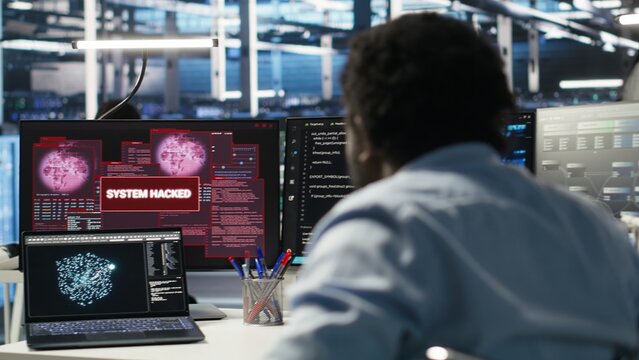 Man with paraplegia in server hub trying to protect hardware from hacker attack stealing sensitive information. Data center specialist in wheelchair fighting virus during security breach, camera B