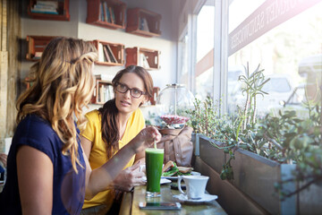 Weekend, friends and women in restaurant in conversation for bonding, social reunion and hangout together. Lunch, cafeteria and people with drink, food and meal for talking, gossip and chatting