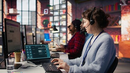 Call center agent uses AI chatbot on laptop to provide quick and accurate replies to common...