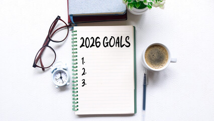 2026 Goals Planner with Notebook, Glasses, Pencil and Coffee on Desk. A top-view image of a notebook displaying 2026 Goals with numbered lines ready for planning