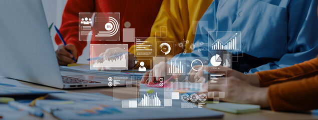 A modern business meeting showcasing a team collaborating on a laptop, with data visualization...