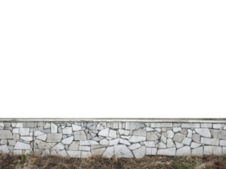 Wall faced with broken white marble pieces forming a mosaic pattern, with dry grass at the base.