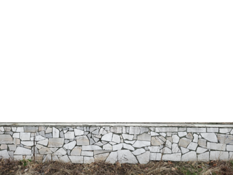 Wall faced with broken white marble pieces forming a mosaic pattern, with dry grass at the base.