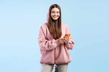 Young woman smiling and holding smartphone, connecting to online social media