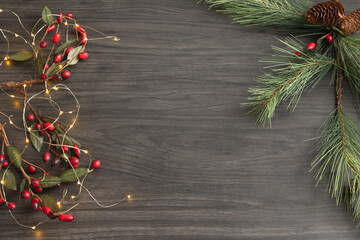 Christmas background with evergreen branch and berries and lights