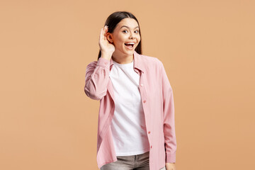 Curious woman with hand to ear listening intently, hearing a secret or gossip