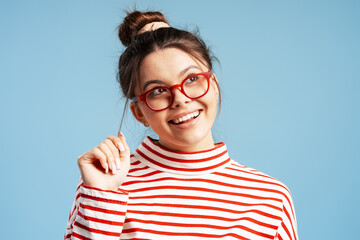Young woman having a good idea, thinking, looking up with a happy expression