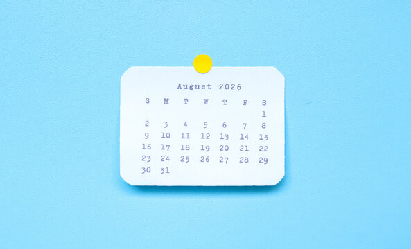 A paper sticker showing August 2026 placed on a blue background. August 2026 sticker attached to a blue background. Minimal and clean calendar concept.