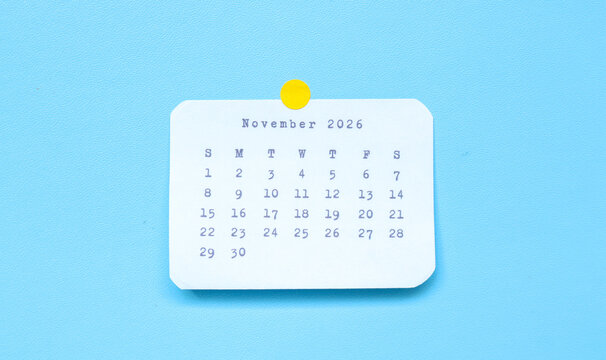 A paper sticker showing November 2026 placed on a blue background. November 2026 sticker attached to a blue background. Minimal and clean calendar concept.