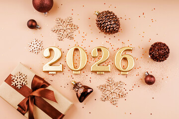 golden 2026 numbers with ribbon wrapped gift snowflakes and holiday baubles on soft pink background...