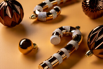 Top view photo of brown and golden christmas tree balls on isolated biege background